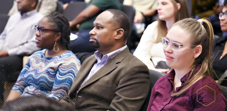 Members of the ASPIRE program sitting in a crowd listening. 