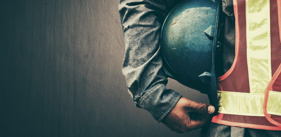 Construction worker holding a helmet