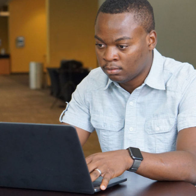 Esterling Accime working on laptop computer