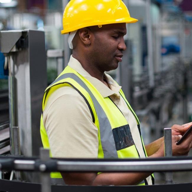 Manufacturing professional working on tablet in factory