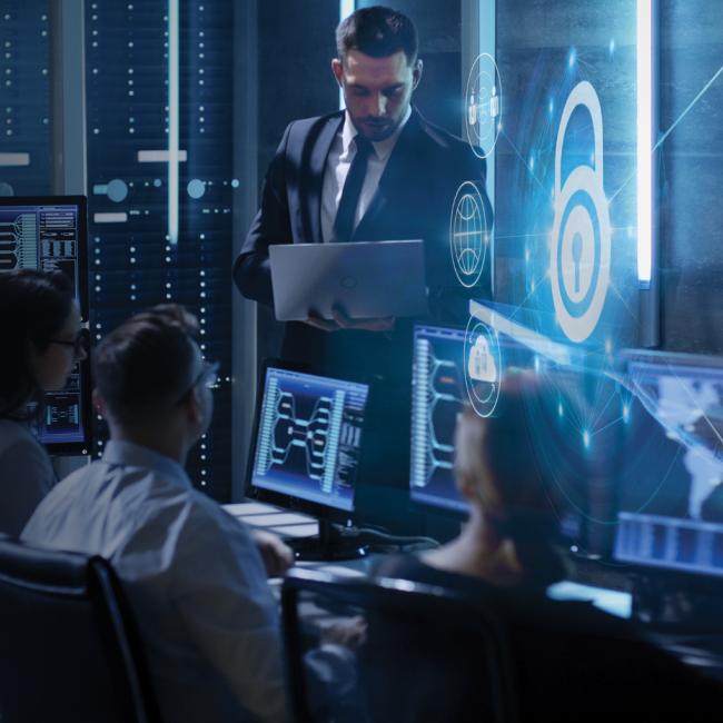 Tech Tower and group of cyber professionals working in front of computers